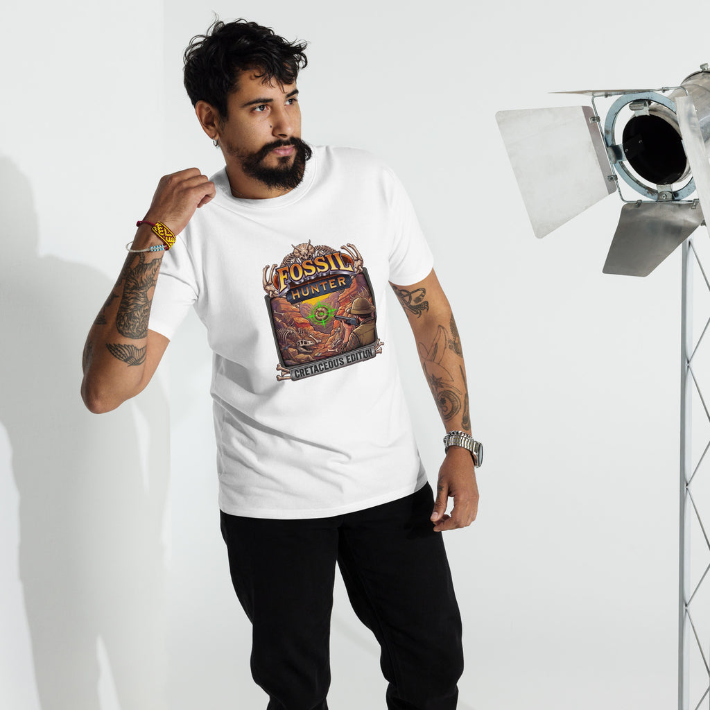 A bearded model wearing a white 100% cotton short-sleeve crewneck graphic t-shirt printed direct to garment on the front with a colorful graphic of a paleontologist fossil hunter targeting ammonite in his crosshairs with a pump action shotgun in a parody of classic arcade hunting games, standing in a studio setting with lights. 
