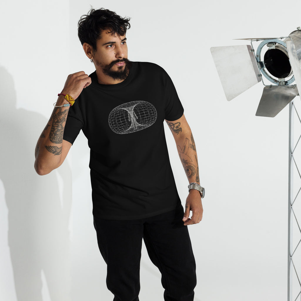 Man standing in a black heavyweight all t-shirt printed with the human toroidal field in a studio setting against a white background