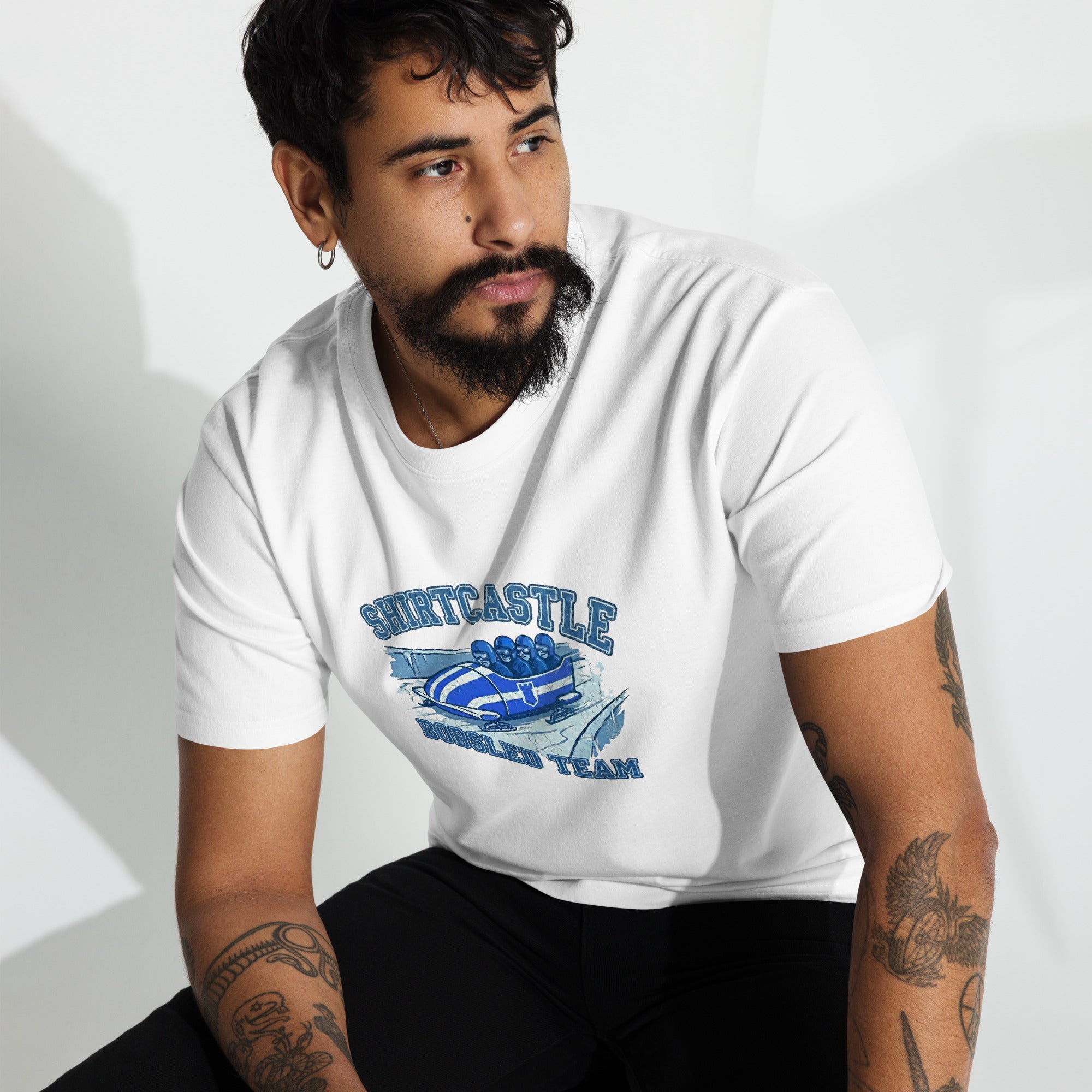 a model sits wearing a white shirtcastle boblsed tee against a white backgroujnd