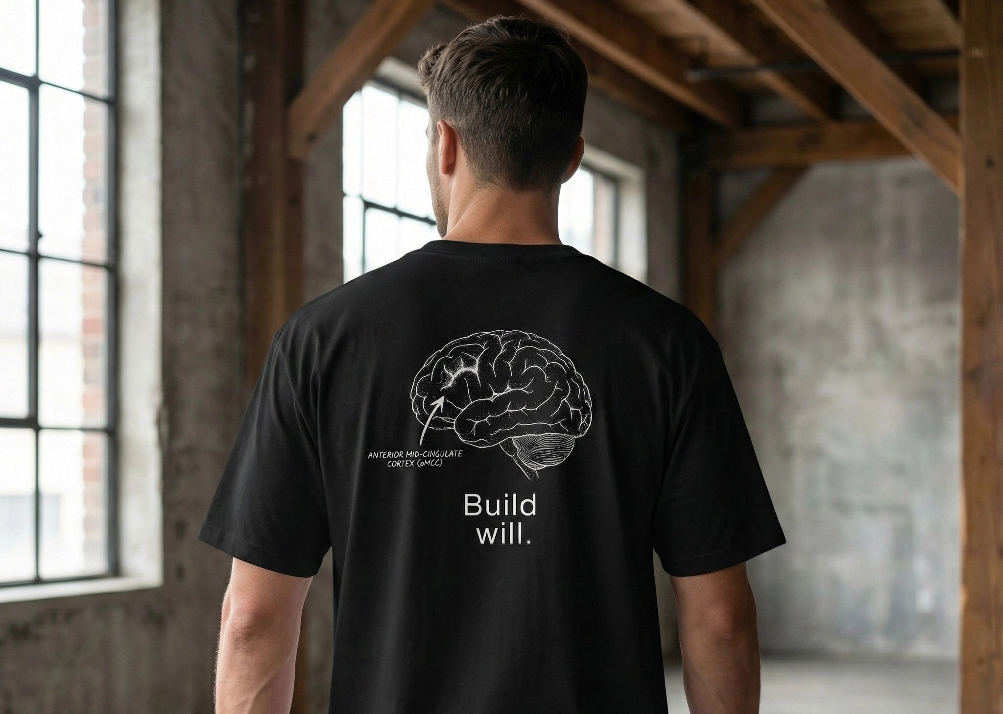 Person wearing a black t-shirt with a brain graphic and text in an industrial setting
