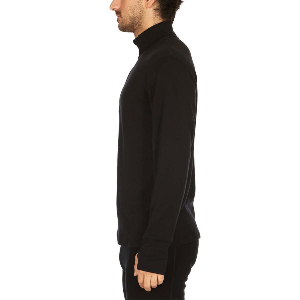A man wearing a black 100 percent merino wool athletic quarter zip shown from the side against a solid white background.