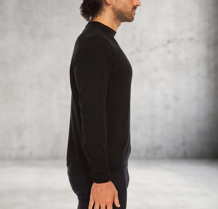 A man wearing a black 100 percent merino wool mock neck shown from the side against a textured grey background.