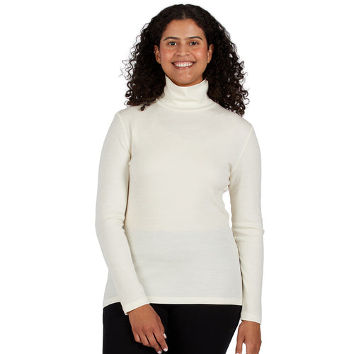 A smiling woman wearing a cream 100 percent merino wool turtleneck shown from the waist up against a solid white background.