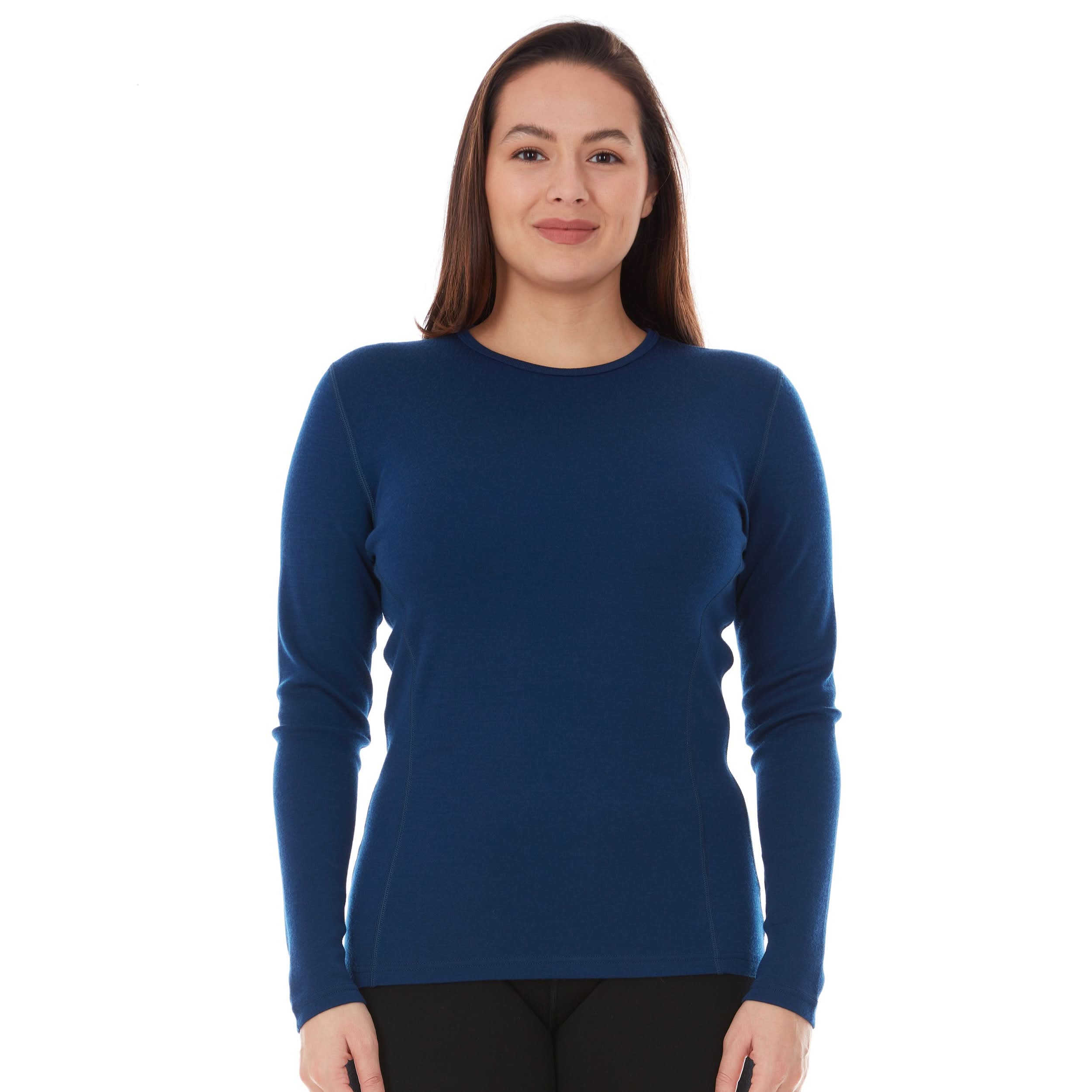 Woman wearing a blue long-sleeve 100 percent merino wool base layer shirt on a white background