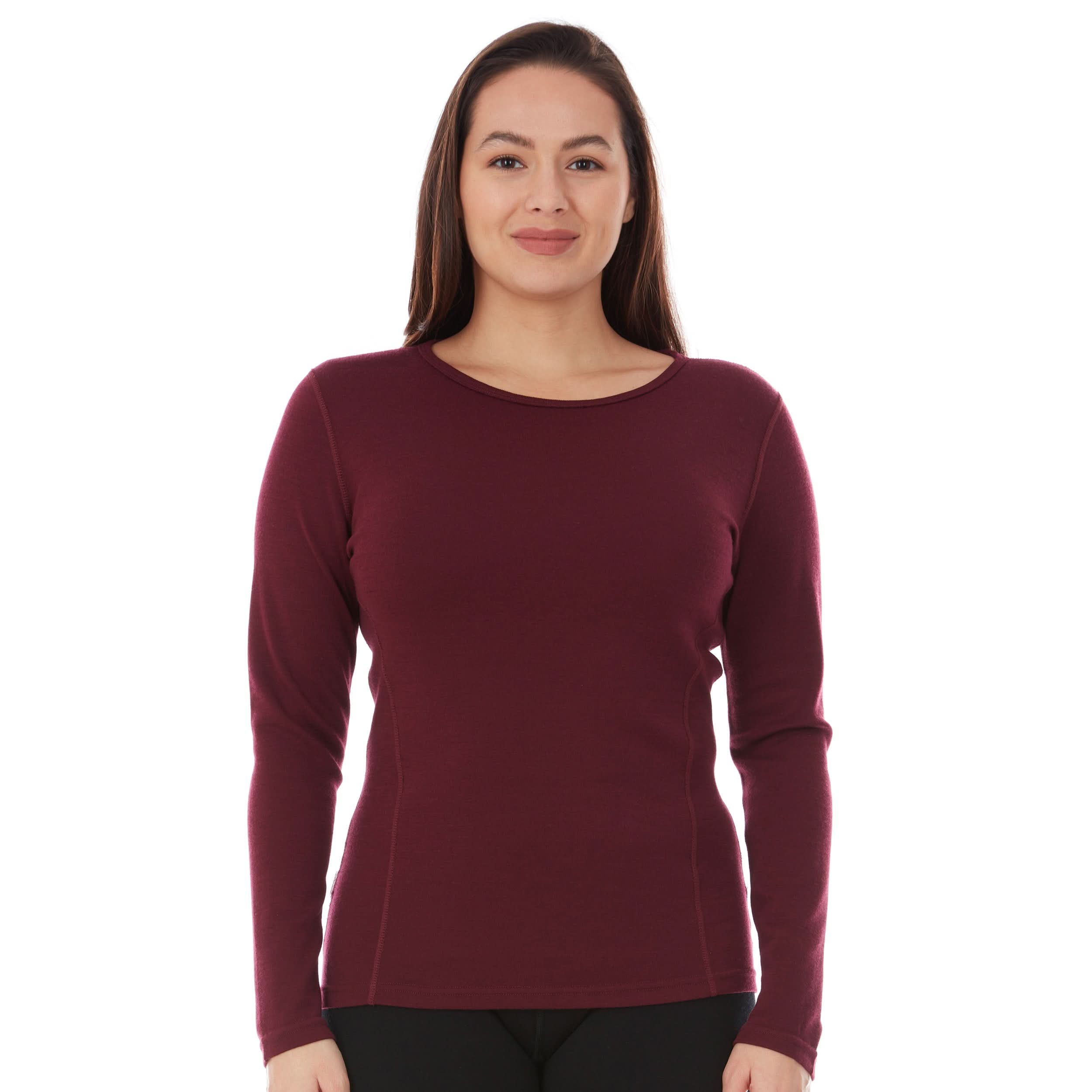 Woman wearing a burgundy long-sleeve princess cut 100 percent merino wool base layer on a white background