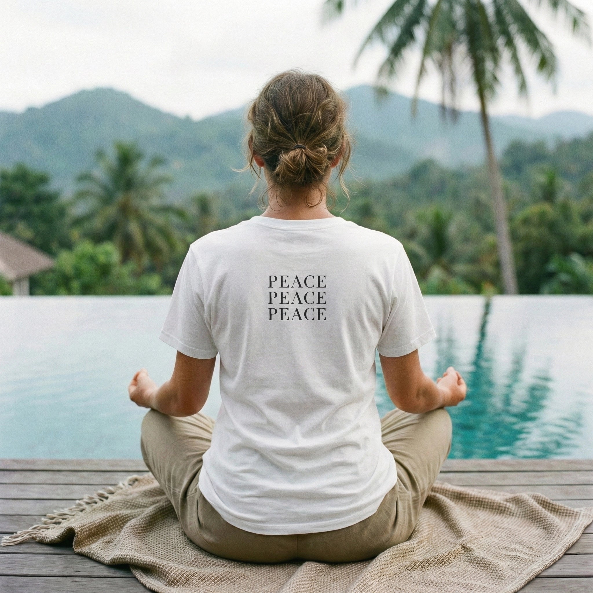 Person meditating by a pool with 'PEACE' t-shirt, surrounded by nature.