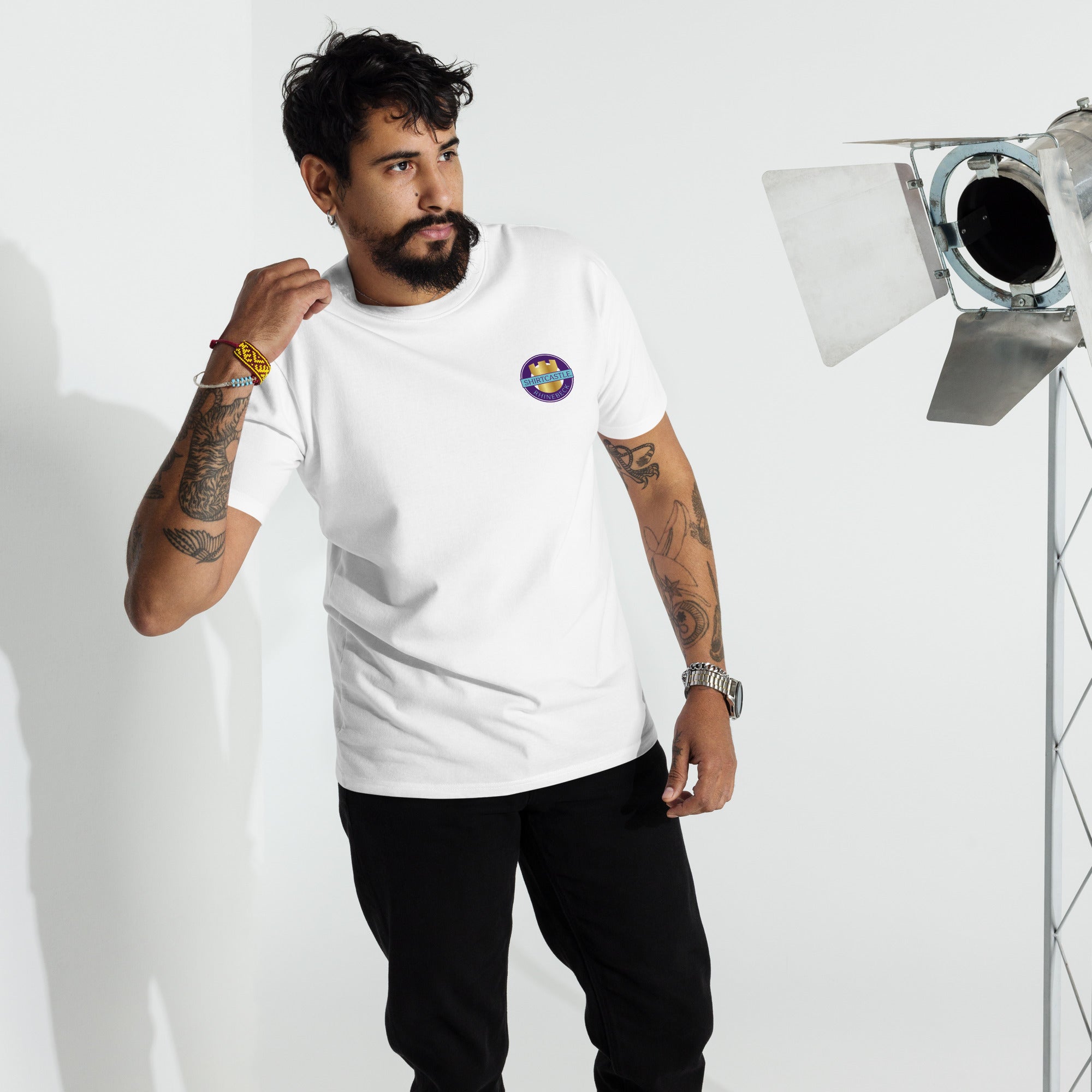 a model wears a white shirtcastle t shirt against a white backdrop with stage lights