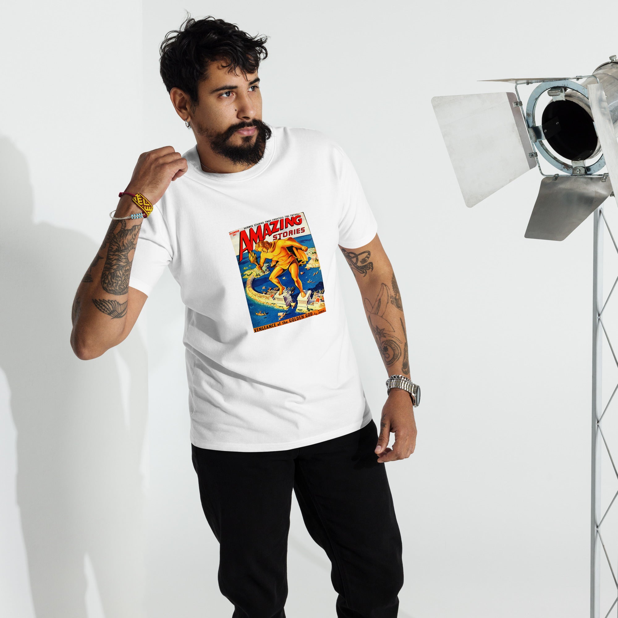 Man wearing a white t-shirt with a colorful graphic from a 1950s magazine cover, standing in front of studio equipment.